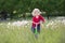 Little baby on a bicycle on a green meadow.