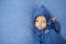 Little baby in blue jumpsuit with hood on his head