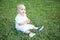 Little baby boy blond dressed in a white shirt posing for the photo