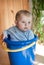 Little baby boy in blue bucket indoor