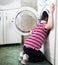 Little baby boy dangerously putting his head into washing machine drum