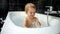 Little baby boy enjoying his bath time and playing with water, foam and sponge. The image highlights the significance of bath time