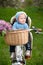 Little baby boy with a hood sitting in bicycle chair