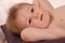 Little baby boy poses for camera laying on pillow