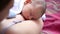 Little baby boy sleeping on mom`s chest outdoor. mother hugging sleeping baby in her arms and kissing the kid gently