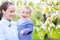 Little baby boy with young mother in the blossoming garden