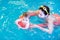 Little baby enjoying swimming pool with her mother