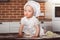 Little baby girl baker in white cook hat and apron