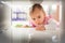 Little baby girl crawl into tight space under coffee table