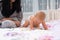 Little baby girl crawling across a bed.