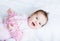 Little baby girl enjoying tummy time in a pink cardigan