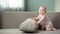 Little baby girl having fun on sofa, discovering world, posing for camera