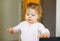 Little baby girl learning walking, standing and making first steps at home. Toddler balancing. Happy child, balance and