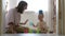 Little baby girl and mommy play with colorful toys at home sitting on floor. Mother and daughter laughing having fun