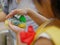 Little baby girl`s hand pressing on the cap of a dishwashing liquid bottle, while helping her mother clean dishes at home