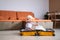 Little baby girl sitting on yellow suitcase baggage luggage, family ready to go for traveling on vacation at home