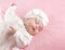 Little baby girl sleeping dressed in white suit