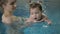 Little baby girl swimming. Learning infant child to swim