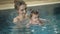 Little baby girl swimming. Learning infant child to swim