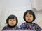 Little baby girls` faces, sisters, 2 and 3 years old, while watching / staring at a smartphone