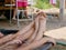 Little baby girls`feet sticking out of water relaxing and resting on the edge of the bucket in a rural area of Thailand