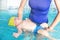 Little baby infant learn to float on back in pool