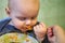 Little baby learn to eat by yourself with a spoon