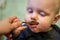 Little baby learn to eat by yourself with a spoon