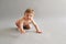 Little baby learns to crawl. emotional portrait of a child on grey background with a copy space