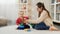 Little baby with mother learning assembling colorful toy pyramid on floor in living room. Baby development, child playing games,