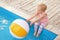 Little baby reaching for inflatable ball at swimming pool. Dangerous situation