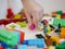Little baby`s hand picking / choosing a piece of colorful interlocking plastic bricks