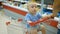 Little baby sitting in a grocery cart in a supermarket, while his father chooses purchases.