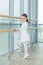 Little ballerina girl. Adorable child dancing classical ballet in a white studio.