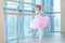 Little ballerina girl in a pink tutu. Adorable child dancing classical ballet in a white studio. Children dance. Kids