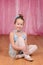 Little ballerina girl sitting on stage