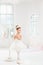 Little ballerina girl in a tutu. Adorable child dancing classical ballet in a white studio.