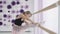 Little ballerina stretching while holding ballet barre