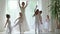 Little ballerinas dance with the teacher in a ballet school. Beautiful little ballerinas are engaged in the ballet at