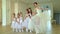 Little ballerinas dance with the teacher in a ballet school. Little schoolgirls of the ballet beautifully dance to quiet