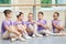 Little ballerinas sitting on the floor.