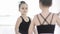 Little ballet girl in leotard are posing in front of the mirror