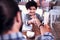 Little beaming dark-haired son looking at his father sitting in cafe together