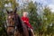 A little beautiful girl in a barnyard walks with a horse,