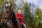 A little beautiful girl in a barnyard walks with a horse,