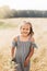 A little beautiful girl collects daisies in the meadow