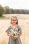 A little beautiful girl collects daisies in the meadow