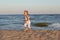 Little beautiful girl frolic on the sandy seashore