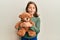 Little beautiful girl hugging teddy bear making fish face with mouth and squinting eyes, crazy and comical