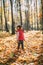 Little beautiful girl loves autumn, walks in autumn forest